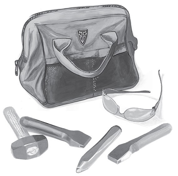 A swept grip tool set laid out consisting of hammer chisels points and safety googles with carrying case